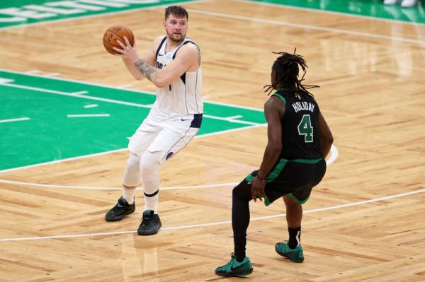 Dallas Mavericks guard Luka Do<em></em>ncic (77) controls the ball against Boston Celtics guard Jrue Holiday (4) during the fourth quarter in game two of the 2024 NBA Finals at TD Garden.