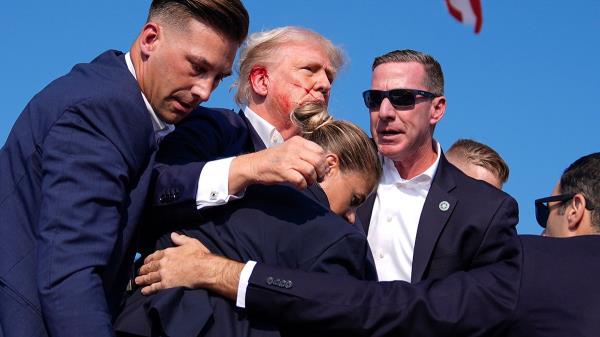 Do<em></em>nald Trump is surrounded by U.S. Secret Service agents at a campaign rally