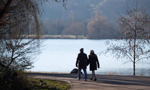 A couple walking in a park during the day.