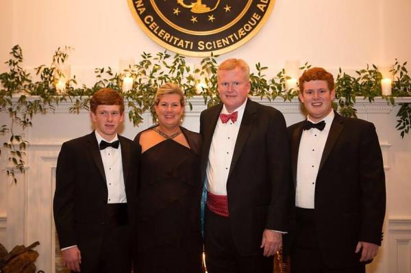 Family photo, with the men in tuxedos and Maggie in a gown.