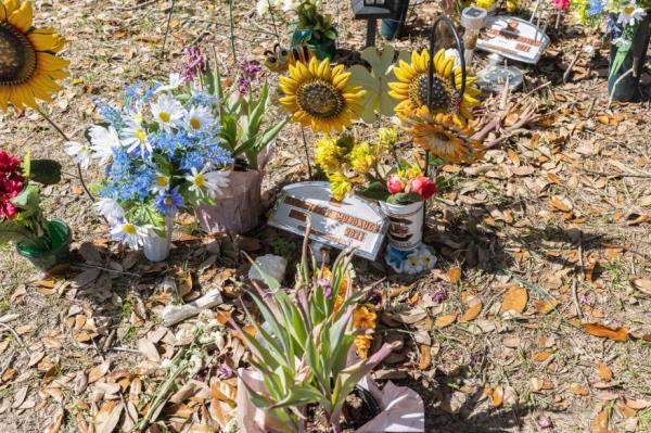 Photo of a grave adorned with fake flowers.