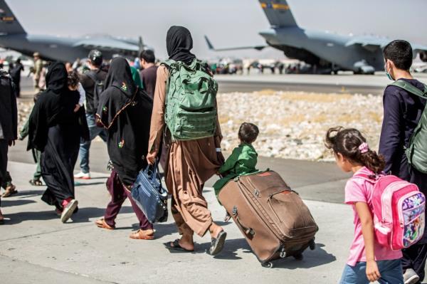 U.S. Marine Corps, families walk towards their flight during o<em></em>ngoing evacuations at Hamid Karzai Internatio<em></em>nal Airport, in Kabu