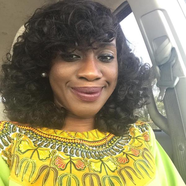 Dwumfour smiles in a selfie in a yellow patterned blouse.