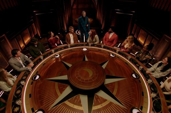 Cast members sit at the round table in 