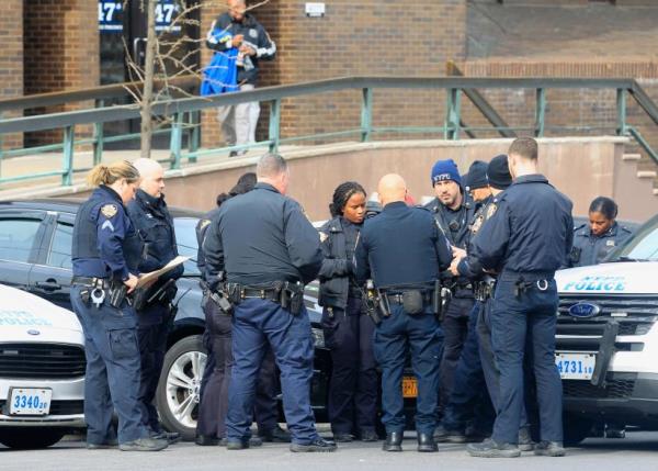 Police officers gathered outside of the 47th Precinct after the shooting.
