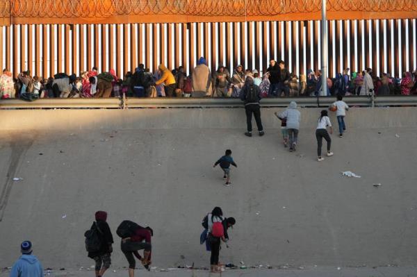 Migrants who crossed the U.S.-Mexico border wait to be transported by U.S. Customs and Border Protection officers.