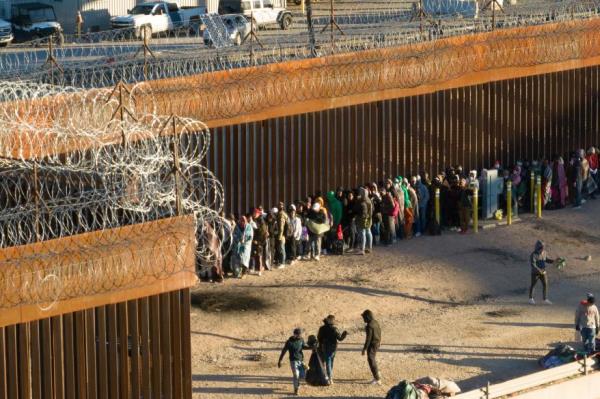 Migrants who crossed the U.S.-Mexico border wait to be transported by U.S. Customs and Border Protection officers.