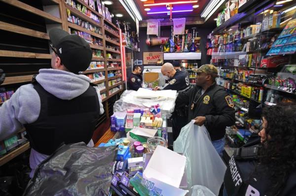 An officer walks into 181 Co<em></em>nvenience in Washington Heights.