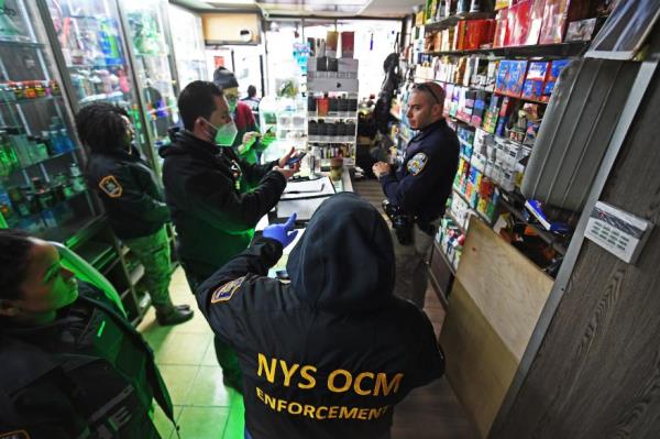 Officers talk to each other during a raid at an illegal smoke shop.