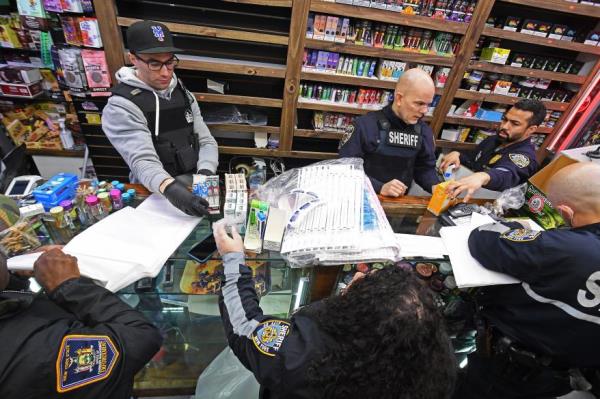 Officers collect evidence during Monday's raids.