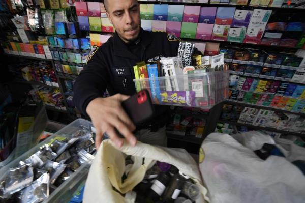 Police collect evidence at a smoke shop.