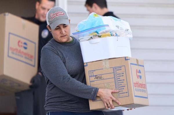 An officer carrying a box marked 