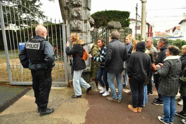 o<em></em>nlookers gather at the entrance of Saint-Thomas d'Aquin school.