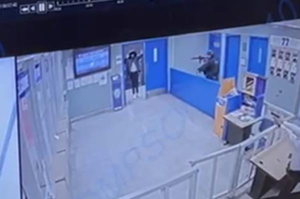 Oliver standing with his hands up in the lobby of the station