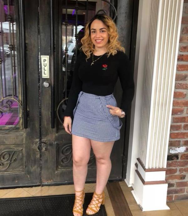 Luz Hernandez poses in front of a front door. 