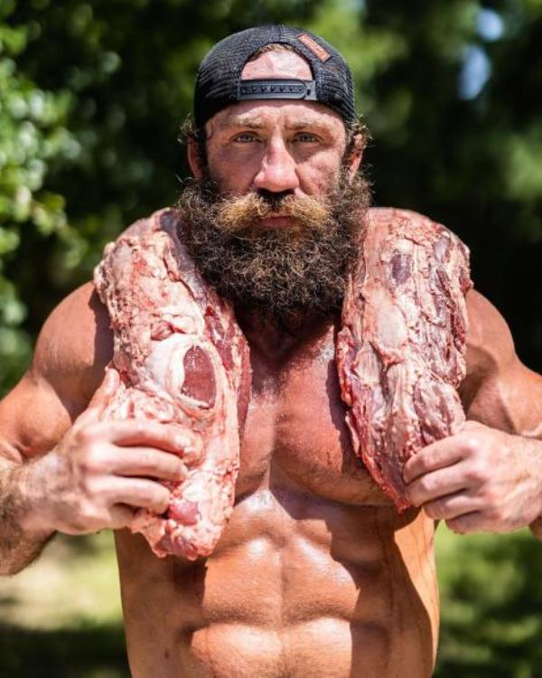 Liver King poses with some raw meat, which he now admits is not th4e secret to his muscular f<em></em>rame.