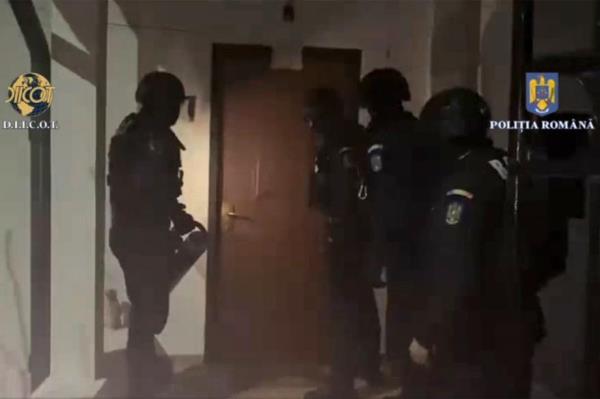 Romania police ready their battering ram to make entry into Tate's villa.