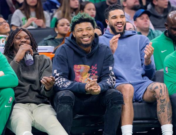 (L) Robert Williams III, Marcus Smart and Jayson Tatum enjoy themselves from the bench during the regular season finale win against the Hawks on April, 2023. 