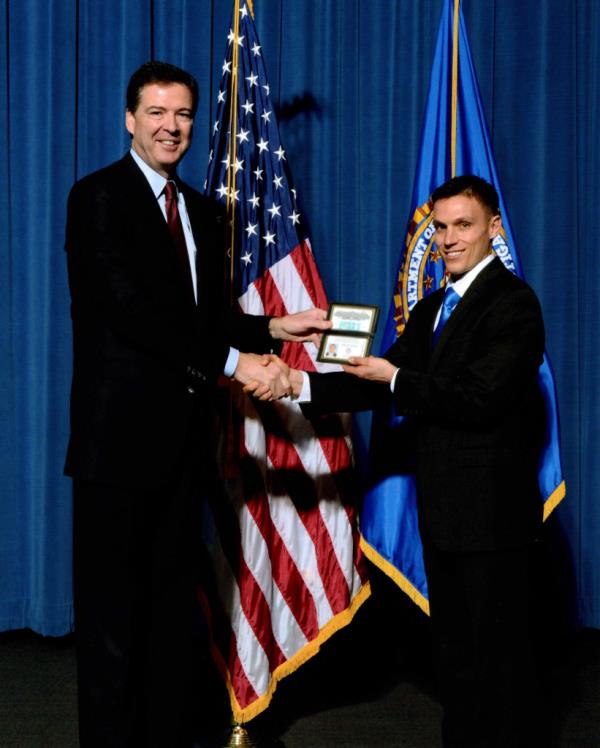 Stephen Friend (right), accepting his FBI credentials from then-FBI Director James Comey in 2014.