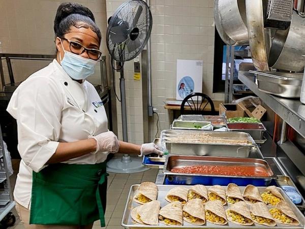 A cook at a city school cafeteria preps a vegan meal. 