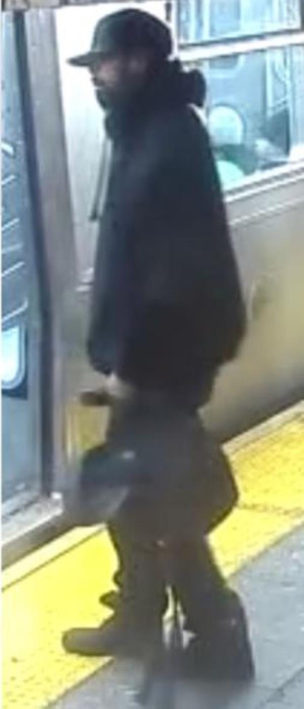 The attacker stands holding the bag.