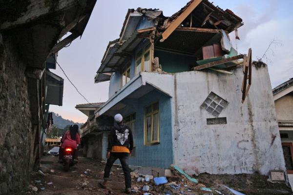 A man walks past a house damaged by an earthquake in Cianjur, West Java, Indonesia, Monday, Nov. 21, 2022. 