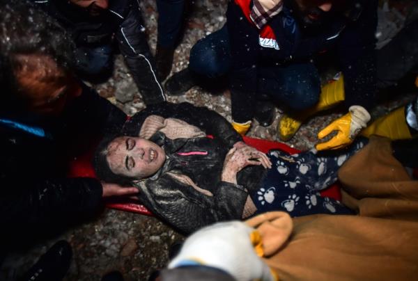 Rescue workers and medics carry a woman out of the debris of a collapsed building in Elbistan, Kahramanmaras, in southern Turkey, Tuesday.