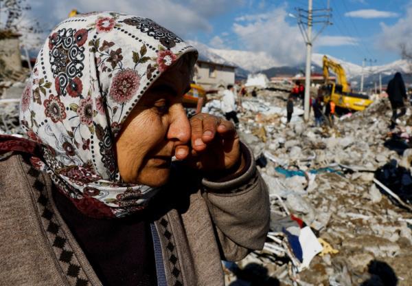 A women weeps as she stands near a pile of rubble in Gaziantep, Turkey.