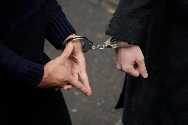 Andrew Tate's hands making diamond-shaped symbol as he arrives at court Monday.