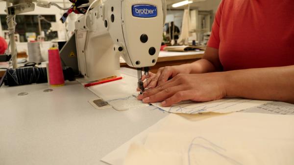 An inmate at HMP Downview practices stitching on a sewing machine.