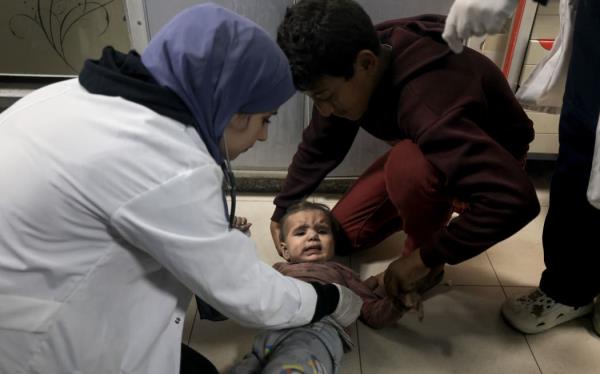 EDITORS NOTE: Graphic co<em></em>ntent / A medic checks a Palestinian child from the Baraka family brought into Nasser Hospital in Khan Yunis, following Israeli air strikes that hit their building in the southern Gaza Strip city on November 13, 2023. Israel is facing intense internatio<em></em>nal pressure to minimise civilian suffering amid a massive air and ground operation that Hamas authorities say has already killed more than 11,000 people, including thousands of children. The military campaign came after Hamas fighters broke through the militarised border with Israel on October 7, killing around 1,200 people, mostly civilians, and taking a<em></em>bout 240 people hostage, according to the most recent Israeli figures. (Photo by Mahmud HAMS / AFP)