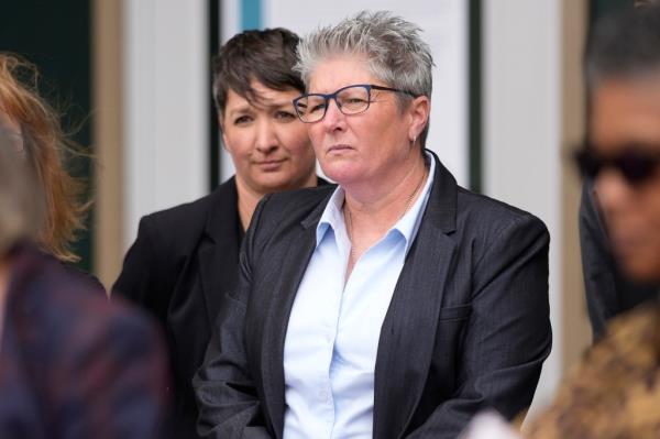 Robin Niceta, behind Chief Vanessa Wilson, who was just dismissed as the chief of police in Aurora, Colo., last week, speaks at a rally in support of her efforts to insure police reforms on the steps of the municipal building Monday, April 11, 2022