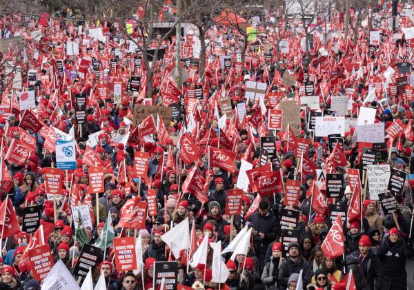 Teachers on strike holding red signs and flags