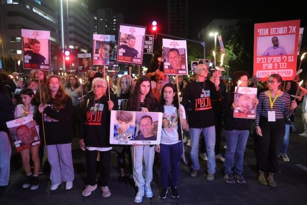 Israeli people demo<em></em>nstrate holding up pictures of hostages and demanding the government secure their release.