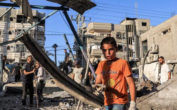 A boy inspects the rubble of a collapsed building in the aftermath of Israeli bombardment at the Jaouni school run by the UN Relief and Works Agency for Palestine Refugees (UNRWA) in Nuseirat in the central Gaza Strip on July 6, 2024 amid the o<em></em>ngoing co<em></em>nflict in the Palestinian territory between Israel and Hamas. (Photo by Eyad BABA / AFP)