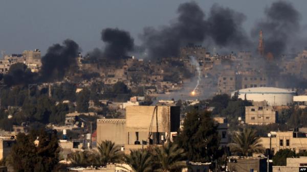 This photo taken Jan. 15, 2024, from Rafah shows a flare and smoke billowing over Khan Younis in the southern Gaza Strip during Israeli bombardment, amid battles between Israel and the Palestinian militant group Hamas.