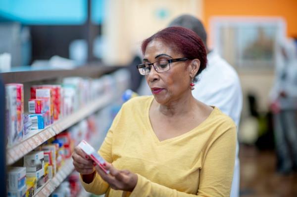 A man looking at a bottle he has just taken from his medicine cabinet